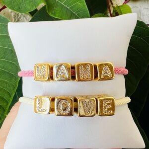 Two Adjustable cord bracelet with gold-plated cubes.